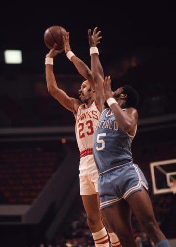 Jim McMillian, Buffalo Braves forward, playing tenacious defense against an opponent during an NBA game.
