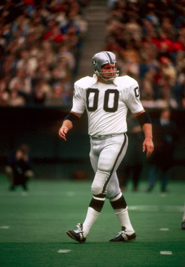 Jim Otto, iconic center for the Oakland Raiders, standing on the field during a game.