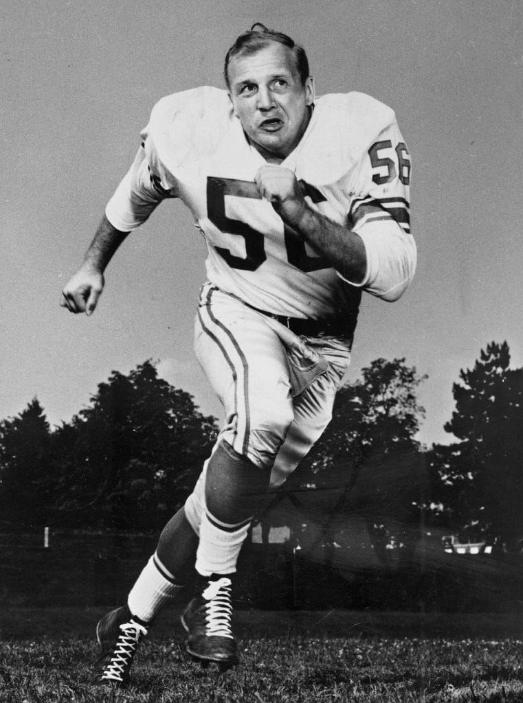 Joe Schmidt, legendary linebacker for the Detroit Lions, captured in a determined run pose during his prime.