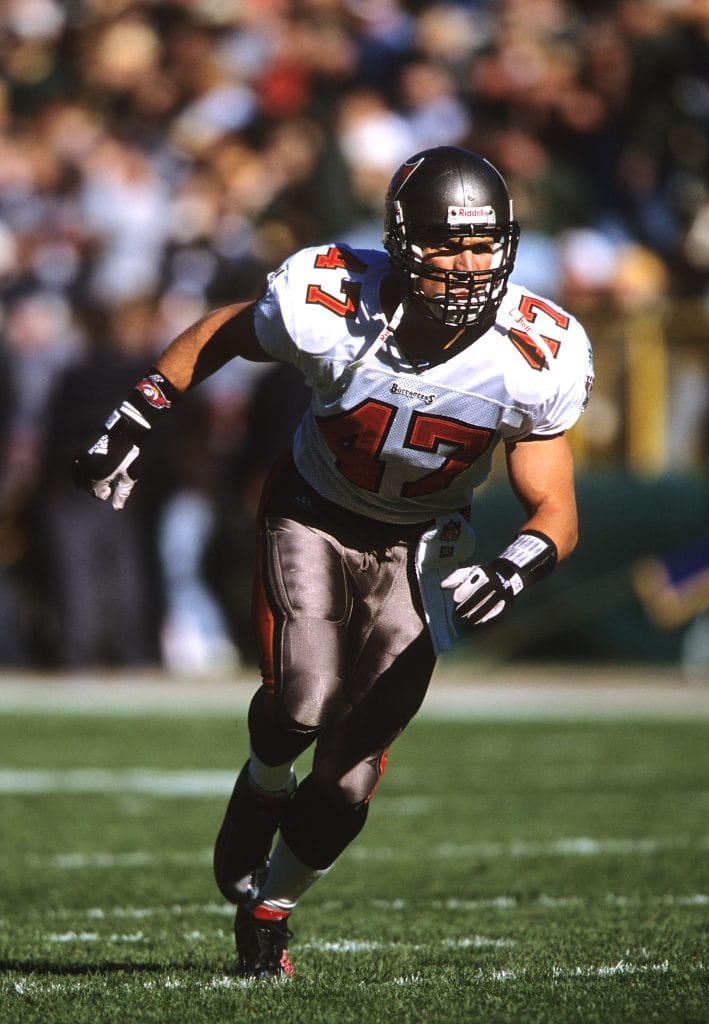 Tampa Bay Buccaneers safety John Lynch sprinting across the field during a game.