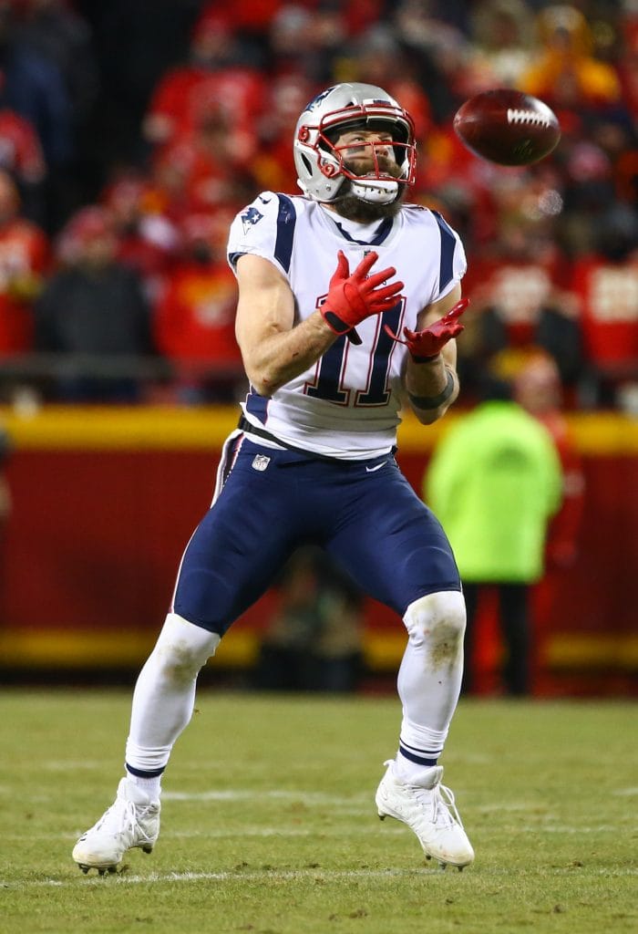 Julian Edelman fielding a punt return in his New England Patriots uniform during a playoff game.
