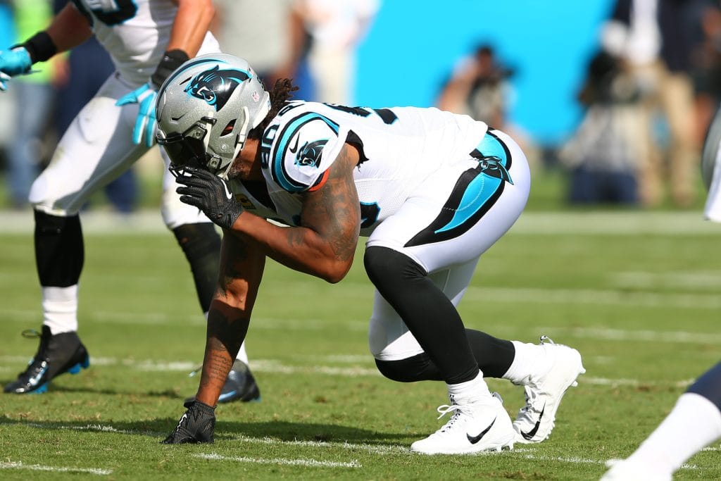 Julius Peppers, Carolina Panthers defensive end, in a crouched stance, preparing for action on the field.