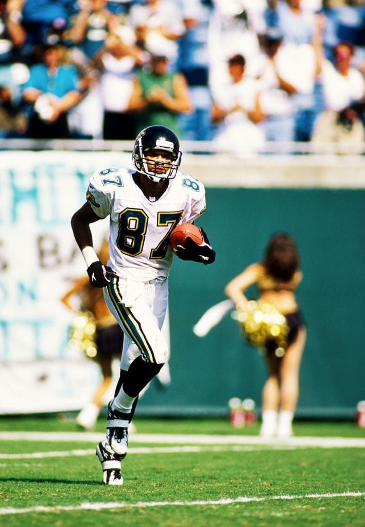 Keenan McCardell, legendary wide receiver for the Jacksonville Jaguars, in action during a game, showcasing his skills that earned him a place among the Top 10 Jacksonville Jaguars of All Time.