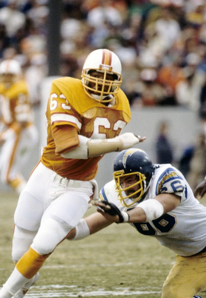 Lee Roy Selmon of the Tampa Bay Buccaneers, wearing jersey number 63, blocking a San Diego Chargers player during an NFL game.