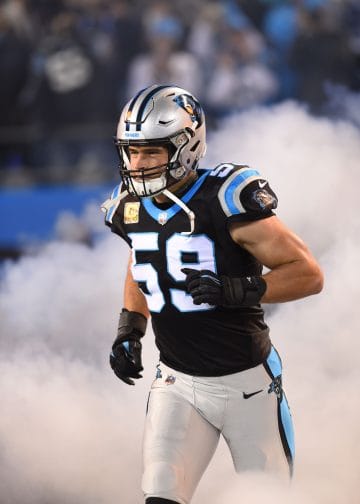 Carolina Panthers linebacker Luke Kuechly runs onto the field through smoke during player introductions.