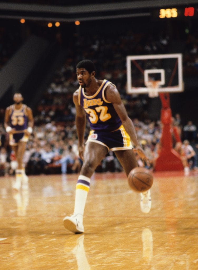 Magic Johnson leading a fast break during a Lakers game, embodying his iconic "Showtime" playstyle.