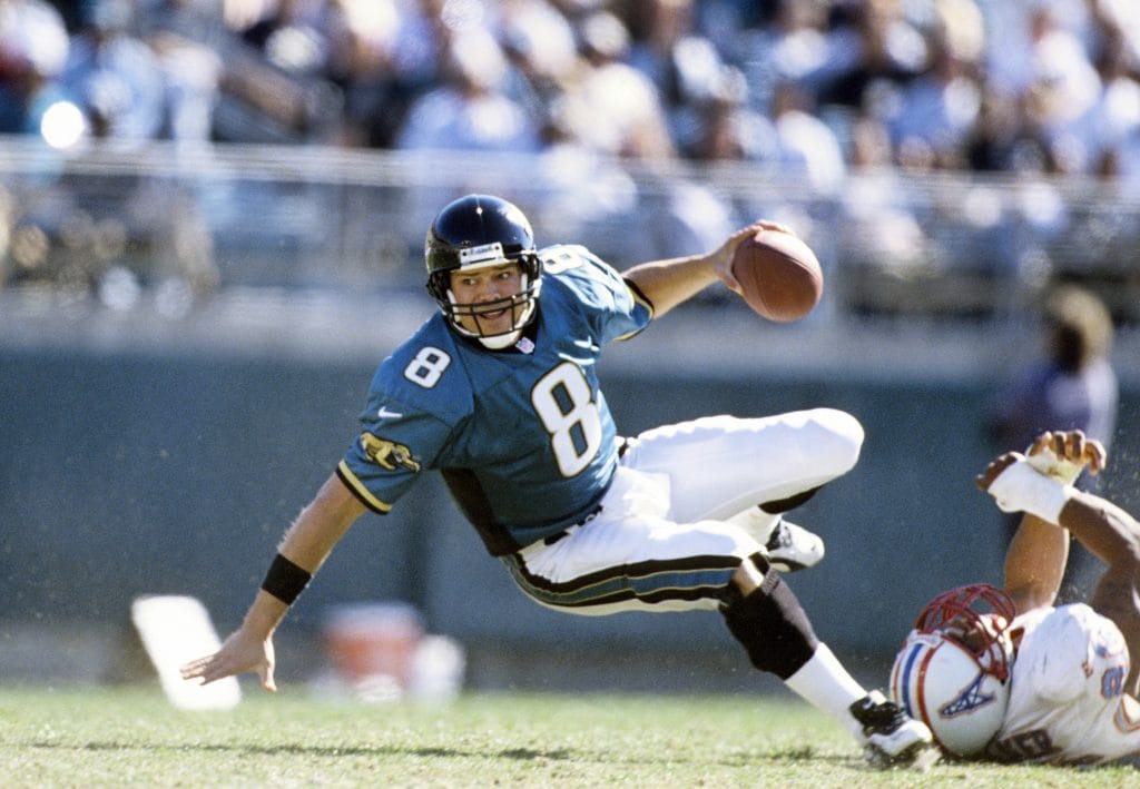 Jacksonville Jaguars quarterback Mark Brunell evading a tackle during a game, wearing jersey number 8.