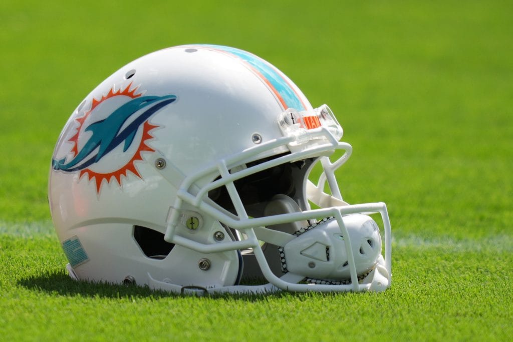 A Miami Dolphins helmet resting on the field, representing the rich history of players featured in the Top 10 Miami Dolphins of All Time.
