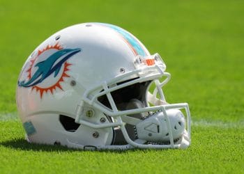 A Miami Dolphins helmet resting on the field, representing the rich history of players featured in the Top 10 Miami Dolphins of All Time.