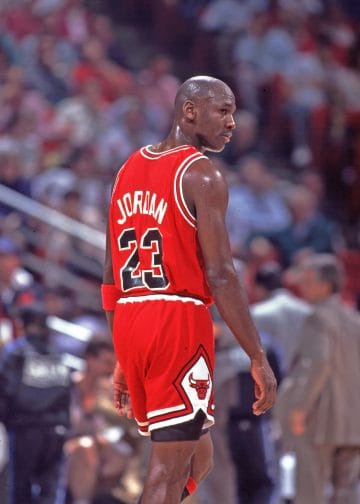 A back view of Michael Jordan wearing his iconic number 23 Bulls jersey, symbolizing his legendary status in NBA history.