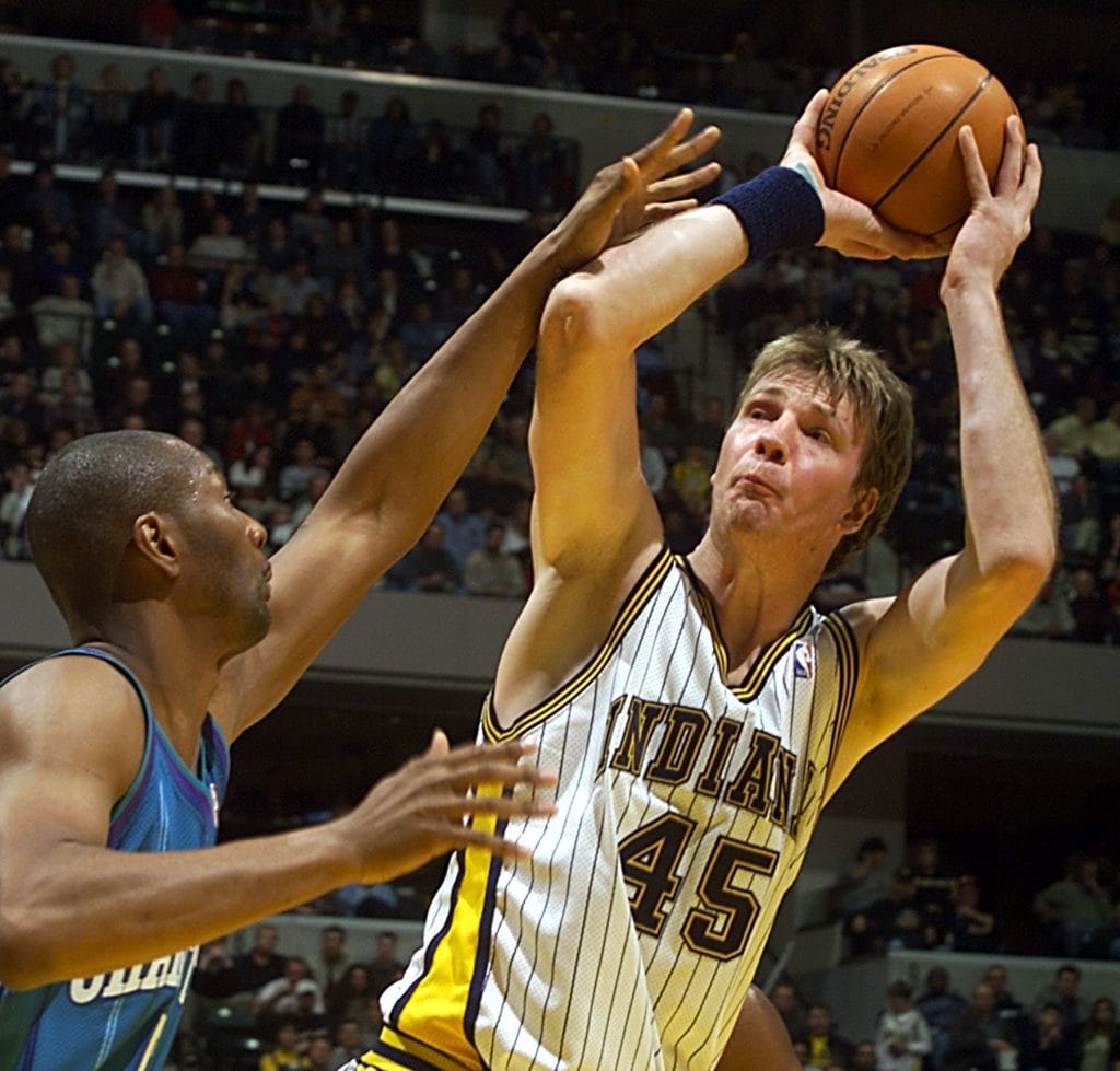 Rik Smits of the Indiana Pacers taking a jump shot during an NBA game.