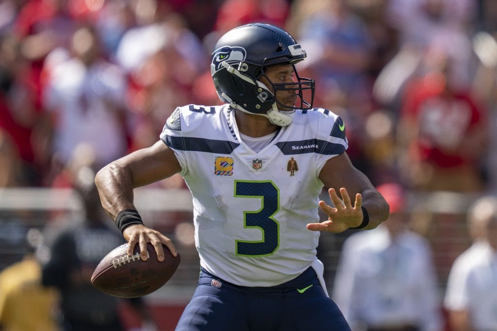 Russell Wilson scanning the field and preparing to throw during a Seattle Seahawks game.