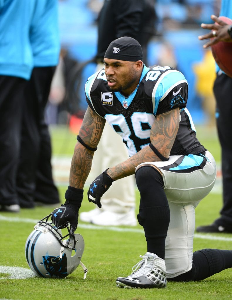 Steve Smith of the Carolina Panthers kneeling on the field with his helmet in hand during pre-game warmups.