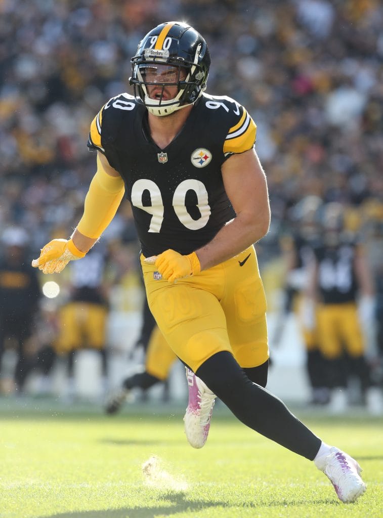 TJ Watt in action during a game, wearing the Pittsburgh Steelers uniform and running toward the play.