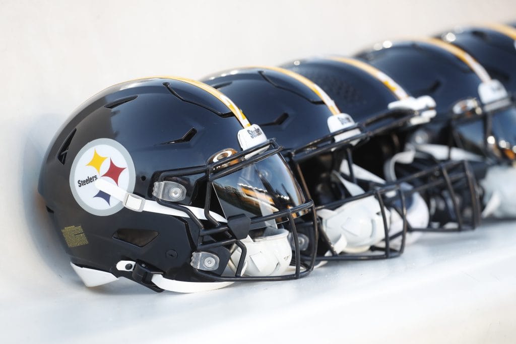 A row of Pittsburgh Steelers helmets on the sideline, representing the Top 10 Pittsburgh Steelers of All Time and their storied legacy.