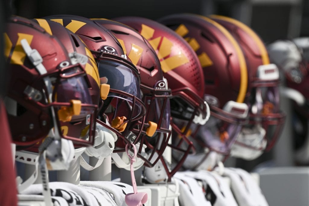 A row of Washington Commanders helmets on the sideline, representing the Top 10 Washington Commanders of All Time and their storied legacy.