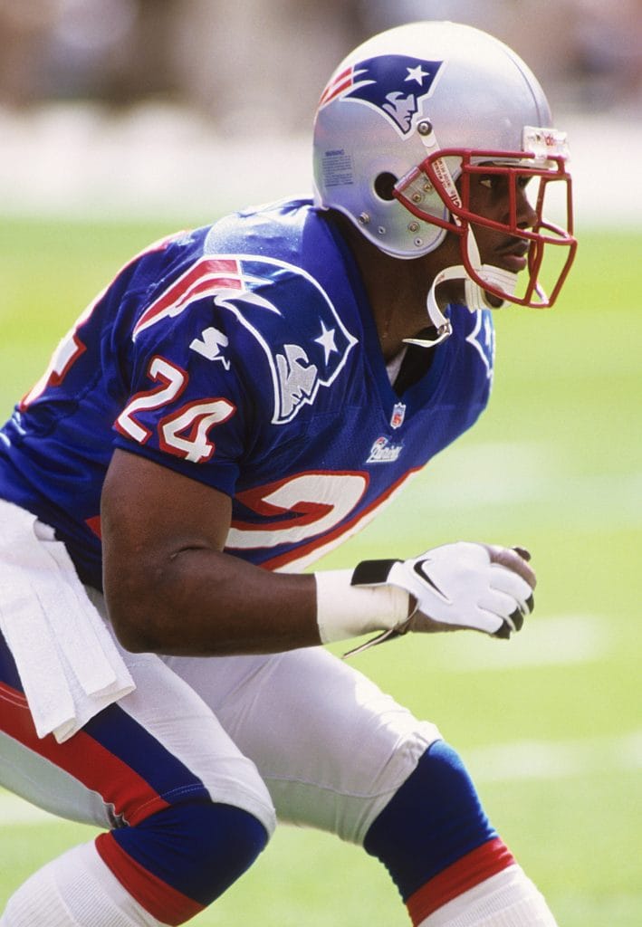 New England Patriots cornerback Ty Law poised and ready in defensive stance during a game.