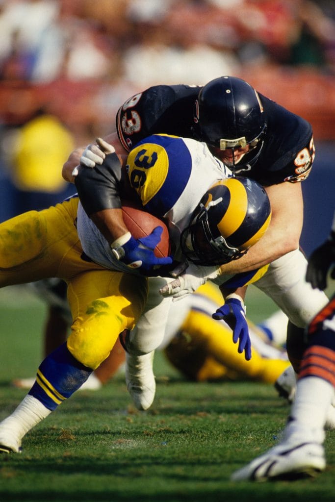 Trace Armstrong, one of the best white NFL players, tackles an opposing player during his time with the Chicago Bears.