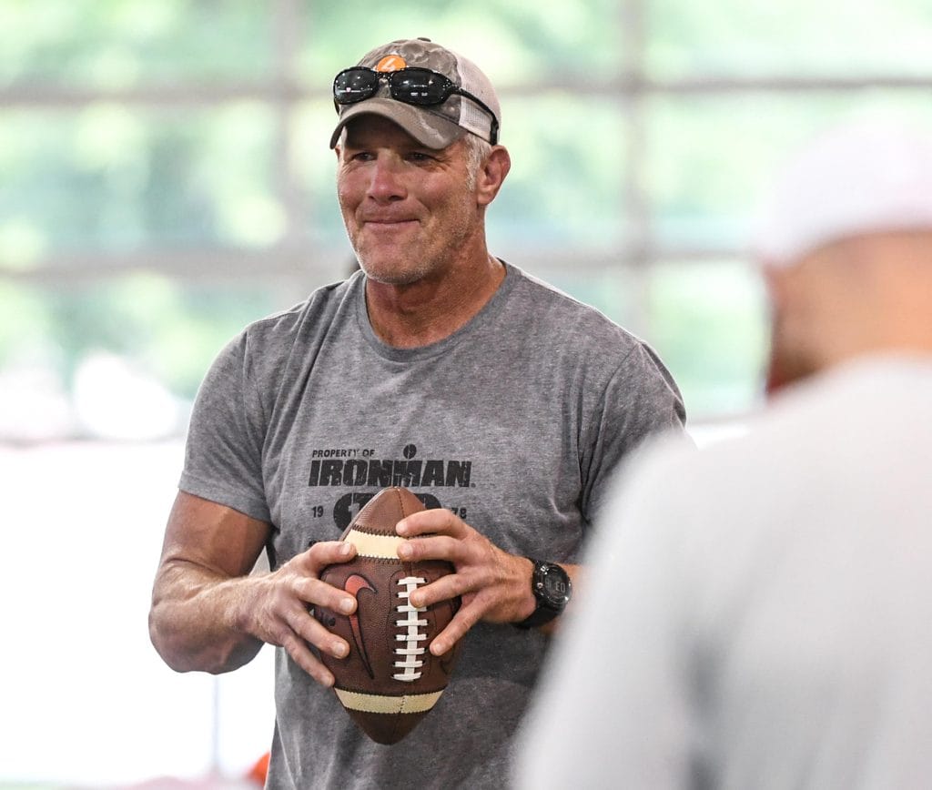 Brett Favre holding a football at practice, showcasing his legacy as one of the best white NFL players and famous white football players.