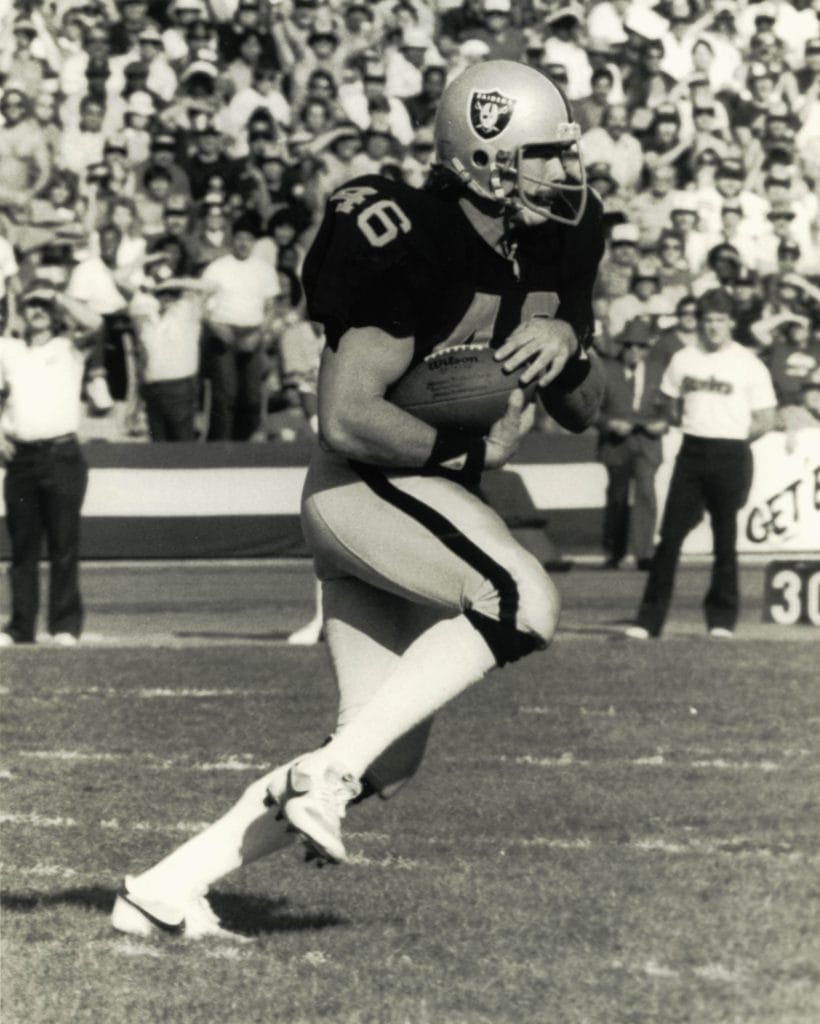Todd Christensen, one of the famous white NFL players, makes a play for the Oakland Raiders during a key game.