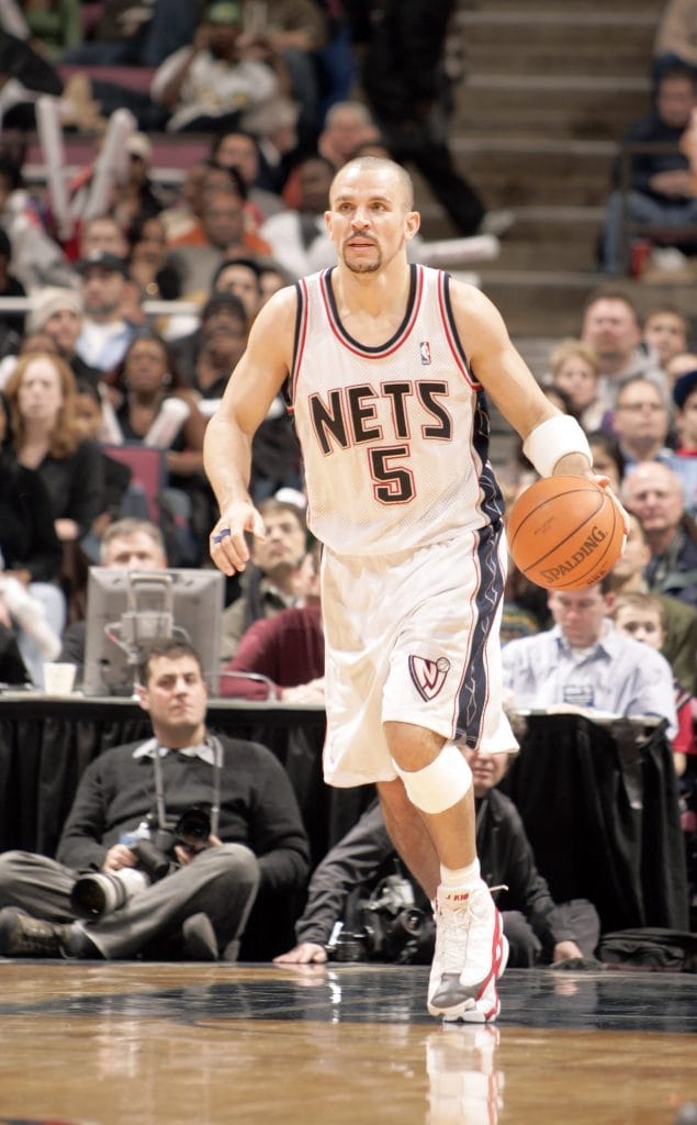 New Jersey Nets point guard Jason Kidd dribbling the ball up the court during an NBA game, wearing the team's white jersey.