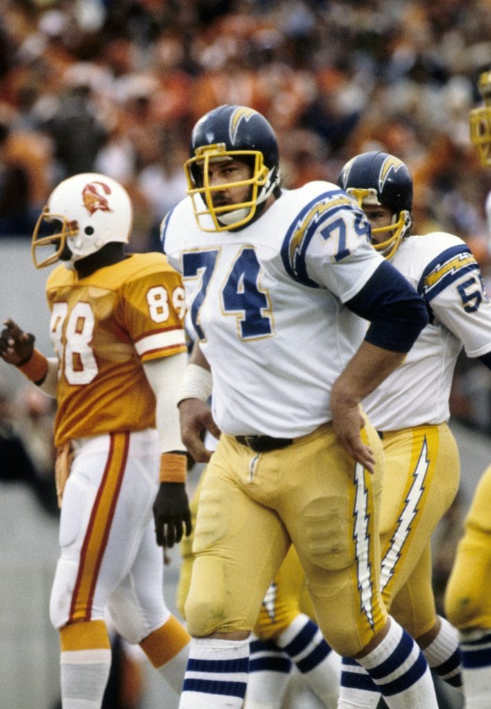 Louie Kelcher stands tall in Chargers uniform, a legendary white NFL player and force in defensive line play.