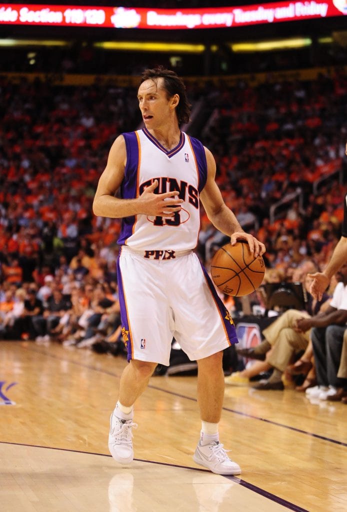 Phoenix Suns point guard Steve Nash dribbling the ball and directing the offense during an NBA game.