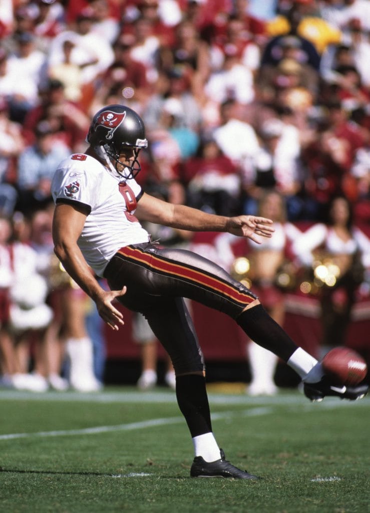 Tom Tupa, famous white NFL player, punting for the Tampa Bay Buccaneers during a game.