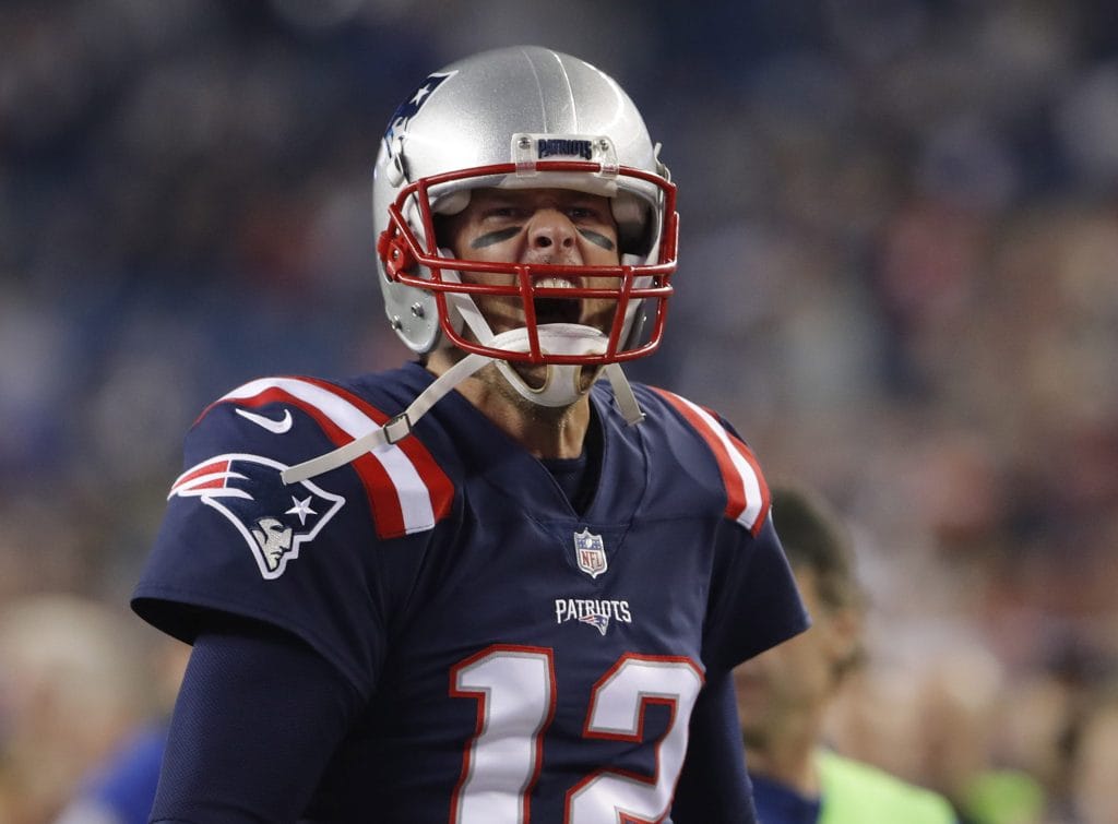 Tom Brady celebrating during a game, showcasing his passion and dominance as one of the Top 10 Quarterbacks Of All Time.