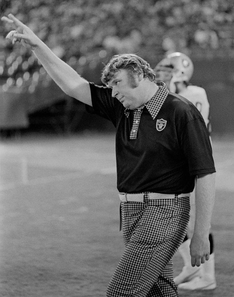 John Madden on the sideline pointing during a game, featured in the list of the Top 10 White NFL Coaches of All Time.