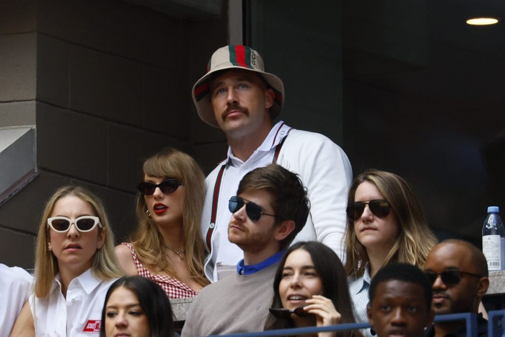 Travis Kelce, one of the most famous white football players, attending a game with Taylor Swift, further elevating his off-field fame.