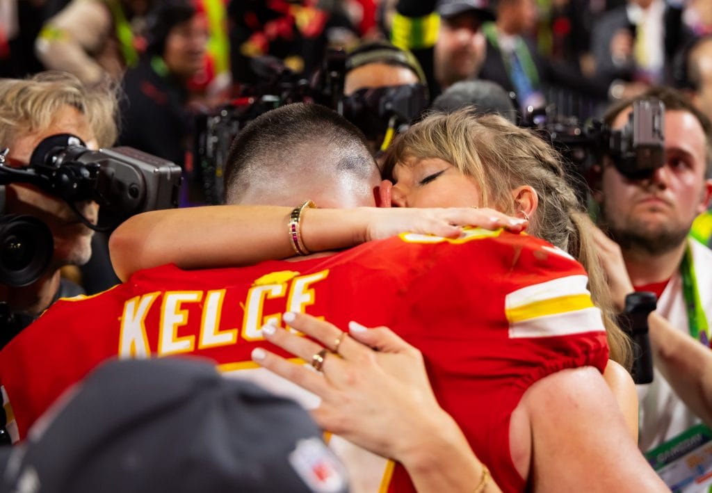Travis Kelce hugging Taylor Swift after the Super Bowl, highlighting his success both on and off the field – famous white NFL players and best TE of all time.