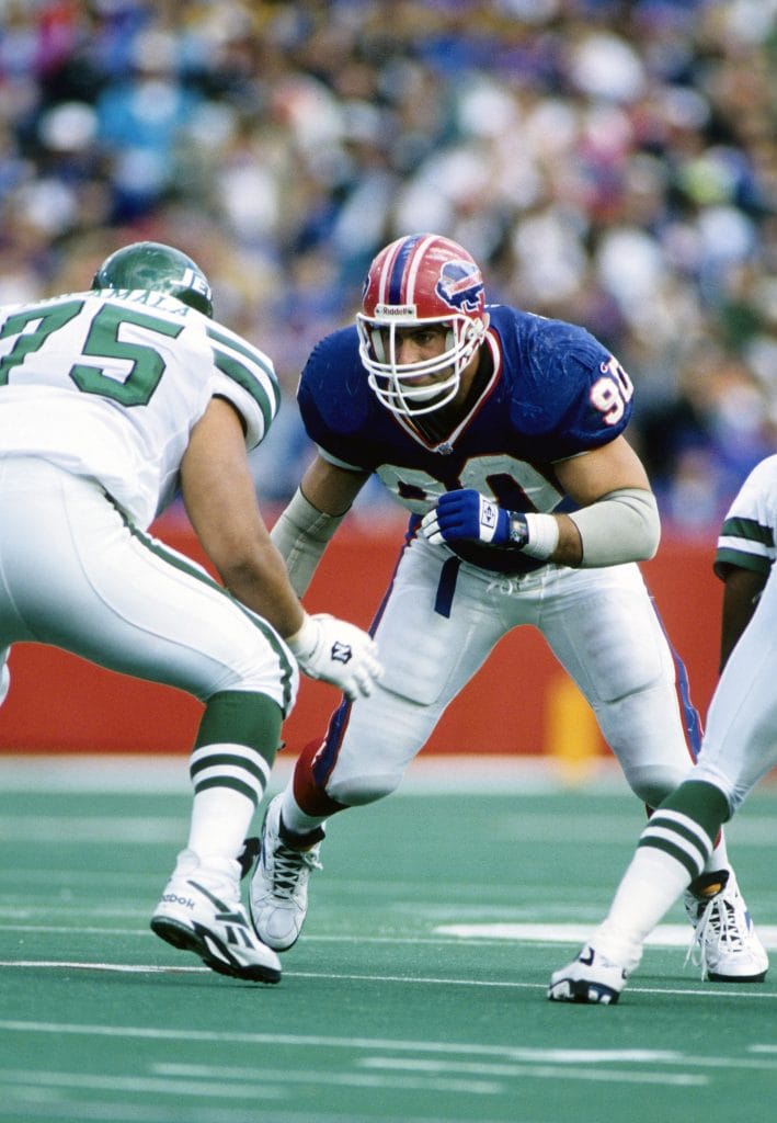 Phil Hansen, a dominant white defensive end for the Buffalo Bills, lines up to rush the passer during an NFL game.