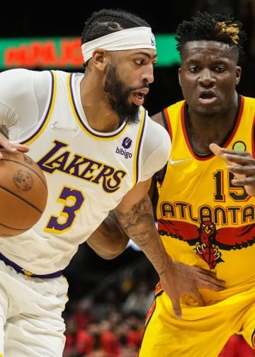 Anthony Davis dribbles past Clint Capela in a game between the Lakers and Hawks.