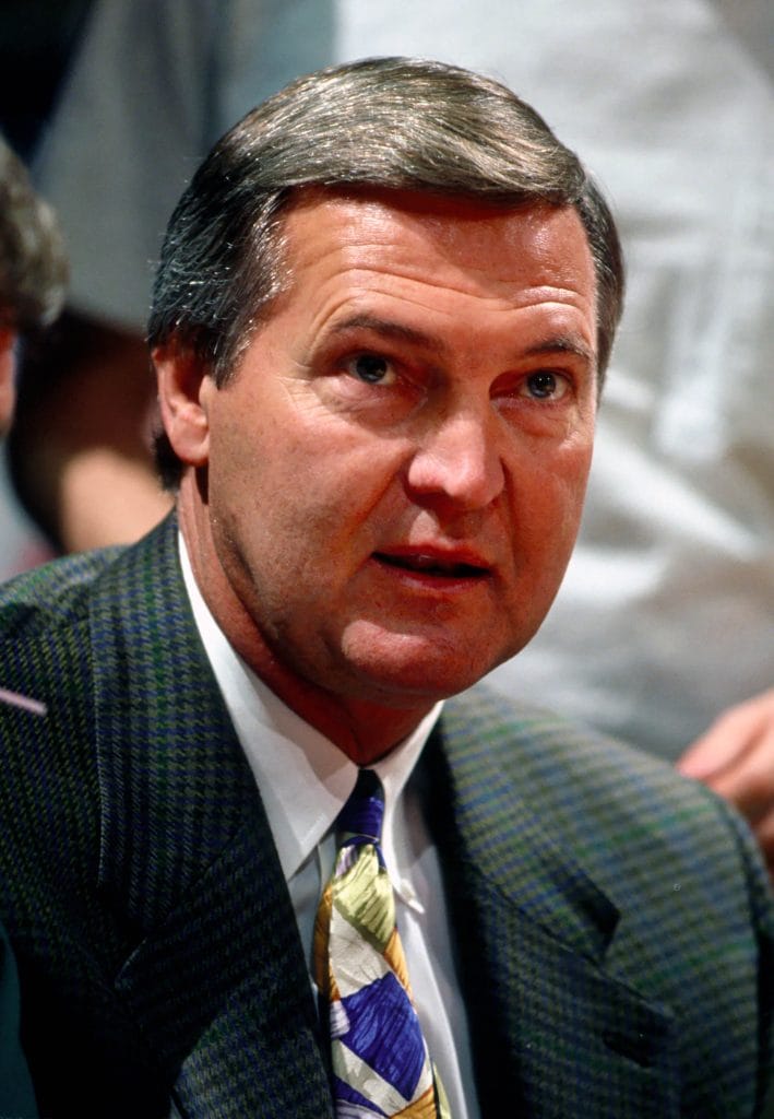 Jerry West in a suit courtside, one of the greatest NBA general managers and a key figure in multiple franchise dynasties