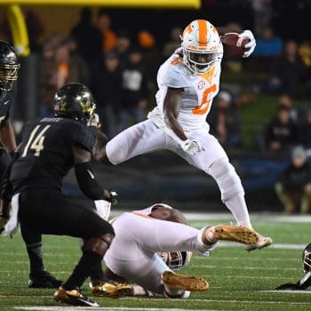 Alvin Kamara hurdles a defender during his time at Tennessee, showcasing athleticism that earned him a spot in the Top 10 Running Backs Who Played 7v7 Football of All Time.