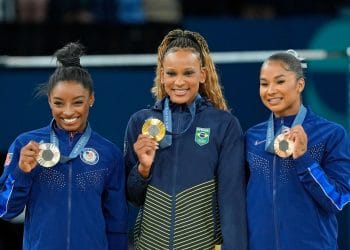 Rebeca Andrade, Simone Biles, and Shilese Jones smiling on the podium after the balance beam final during the Artistic Gymnastics Olympics
