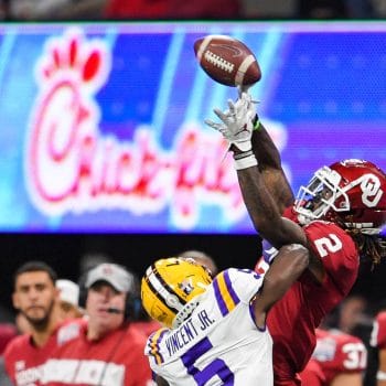 CeeDee Lamb makes a leaping catch over LSU defender during a bowl game.