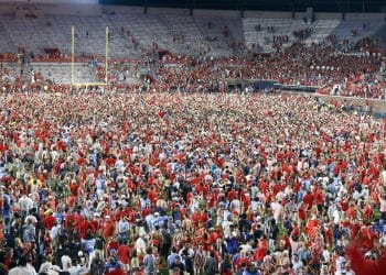 Fans storm the field at Vaught–Hemingway Stadium after Ole Miss victory, capturing the electric atmosphere in Oxford.