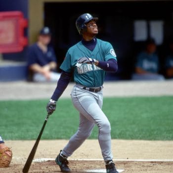 Black baseball player Ken Griffey Jr. watching a deep shot in a Seattle Mariners uniform.