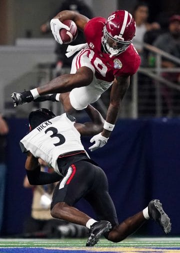 Alabama tight end Jahleel Billingsley hurdles a Cincinnati defender during the 2021 College Football Playoff semifinal earning him a spot on the Top 10 Tight Ends Who Played 7v7 Football of All Time. 