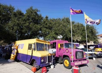 LSU tailgating trucks parked outside Death Valley Stadium with Geaux Tigers flags flying high