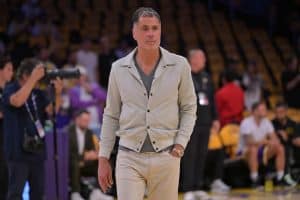 Rob Pelinka walks courtside during a Lakers game, overseeing a team impacted by bad roster moves. 