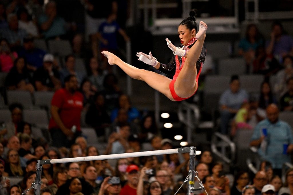 Suni Lee mid-air during her uneven bars release at the Female Artistic Gymnastics Olympics in Paris 2024